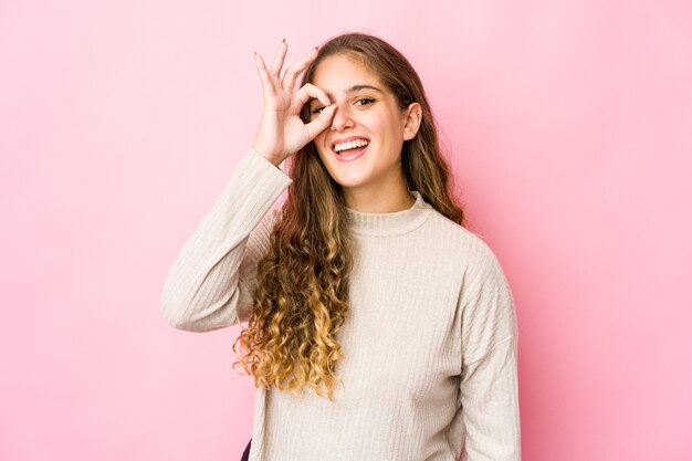 Jonge blanke vrouw opgewonden houden ok gebaar op oog.