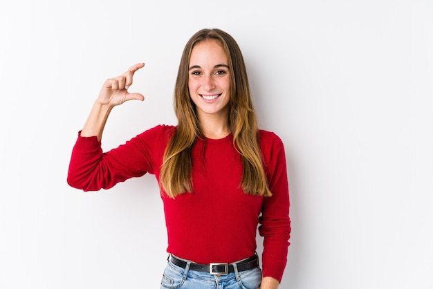 Jonge blanke vrouw poseren geïsoleerd met iets weinig met wijsvingers, glimlachend en zelfverzekerd.