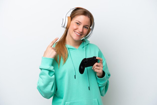 Jonge blanke vrouw spelen met een video game controller geïsoleerd op een witte achtergrond met een duim omhoog gebaar