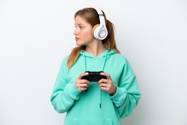 Jonge blanke vrouw spelen met een video game controller geïsoleerd op een witte achtergrond op zoek naar de kant