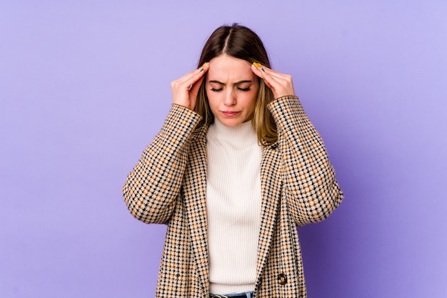 Jonge blanke vrouw tempels aan te raken en hoofdpijn te hebben.