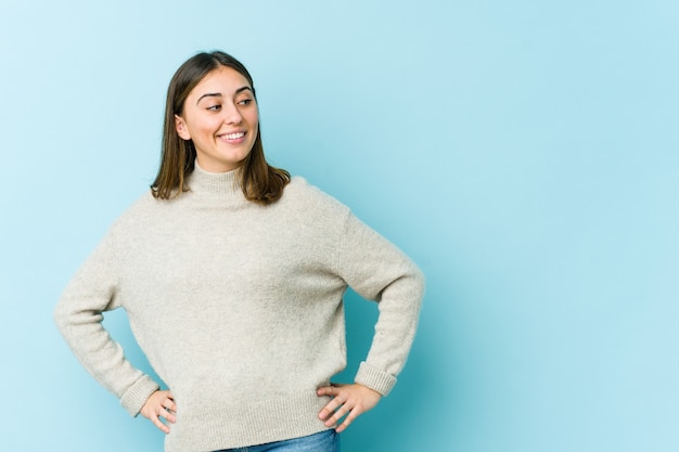 Jonge blanke vrouw vertrouwen houden handen op de heupen.