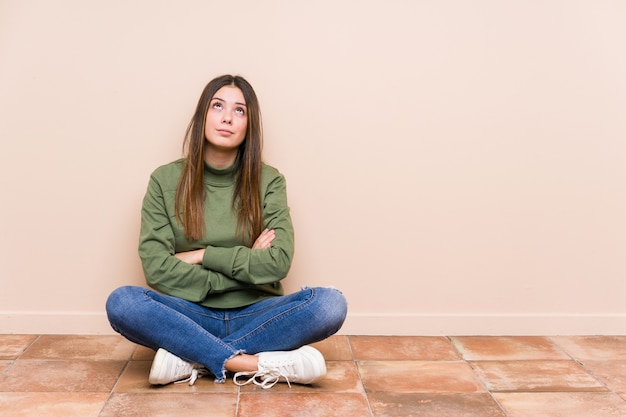 Jonge blanke vrouw zittend op de vloer