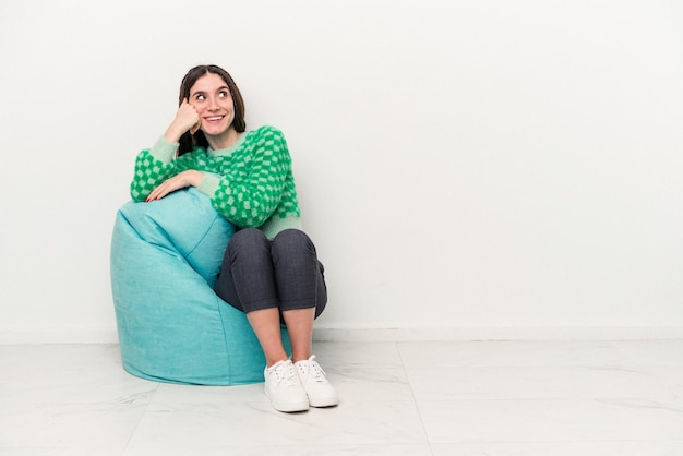 Jonge blanke vrouw zittend op een trekje geïsoleerd op een witte achtergrond