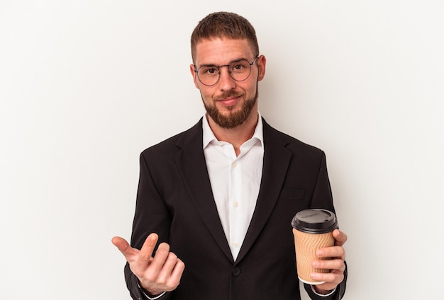 Jonge blanke zakenman met afhaalkoffie geïsoleerd op een witte achtergrond wijzend met de vinger naar je alsof uitnodigend dichterbij komt.