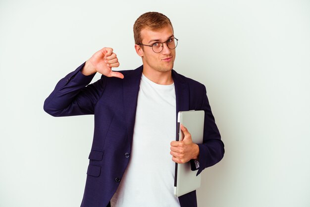 Jonge blanke zakenman met een laptop geïsoleerd op een witte achtergrond voelt zich trots en zelfverzekerd, een voorbeeld om te volgen.