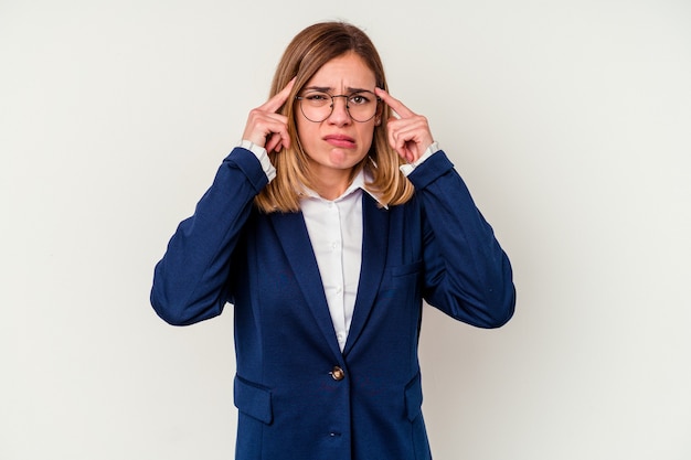 Jonge blanke zakenvrouw concentreerde zich op een taak, met wijsvingers die het hoofd richtten.