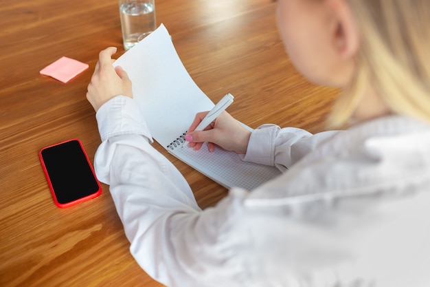 Jonge blanke zakenvrouw die op kantoor werkt, ziet er stijlvol uit. Papierwerk, analyseren