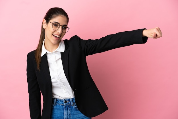 Jonge blanke zakenvrouw geïsoleerd op roze achtergrond met een duim omhoog gebaar