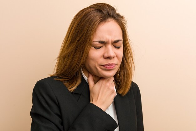 Jonge blanke zakenvrouw lijdt pijn in haar keel als gevolg van een virus of infectie.