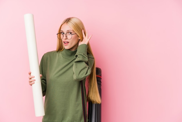 Jonge blonde architectuurstudent die aan een roddel probeert te luisteren.