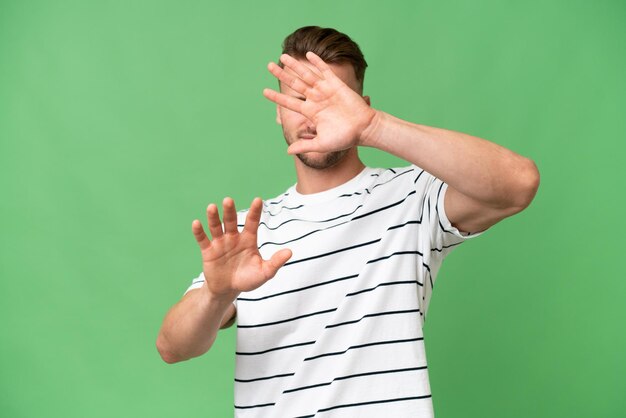 Foto jonge blonde blanke man over geïsoleerde achtergrond nerveus handen naar voren strekken