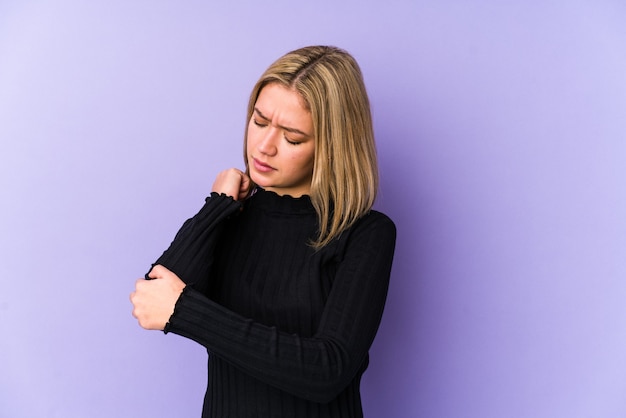 Jonge blonde blanke vrouw geïsoleerd masserende elleboog, lijdend na een slechte beweging.