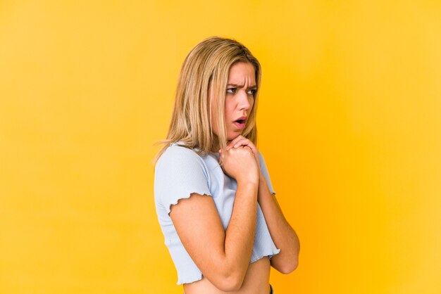 Jonge blonde blanke vrouw geïsoleerd op geel bang en bang.