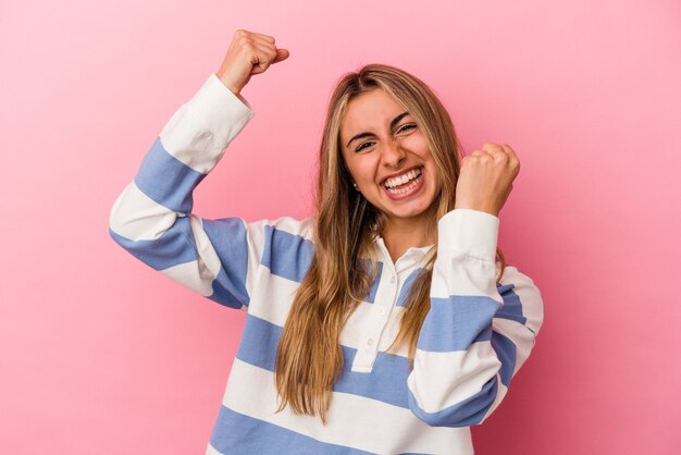 Jonge blonde blanke vrouw geïsoleerd op roze background