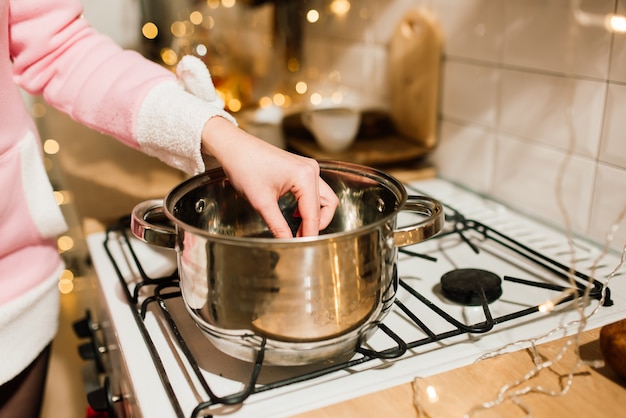 Jonge blonde huisvrouw bereidt kerstdiner in de keuken