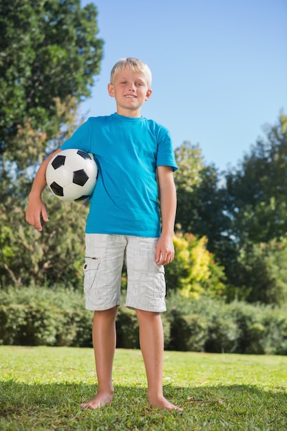 Jonge blonde jongen houdt voetbal