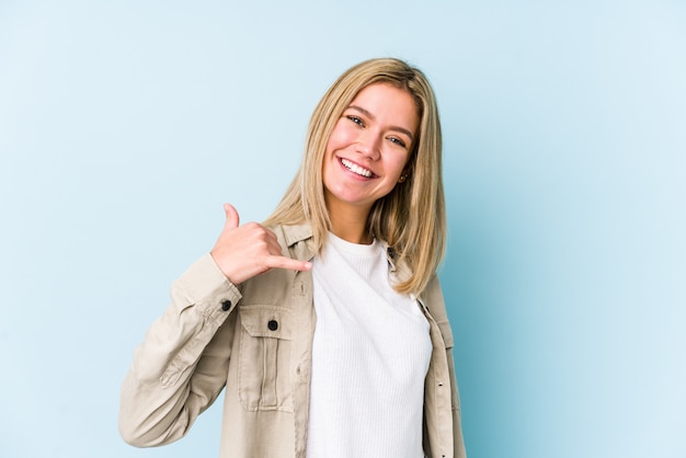 Jonge blonde Kaukasische vrouw die een mobiel telefoongesprekgebaar met vingers toont.