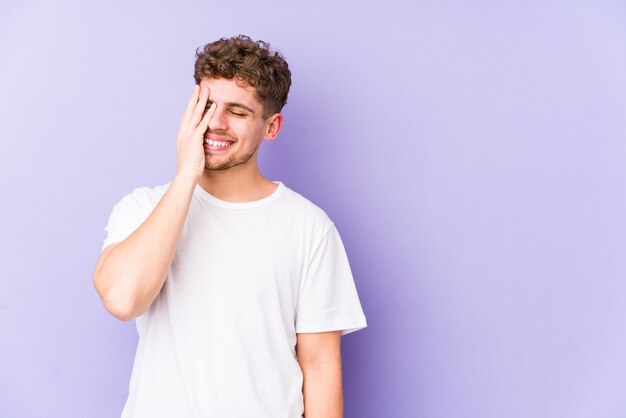 Jonge blonde krullende blanke man geïsoleerd lachen gelukkige, zorgeloze, natuurlijke emotie.