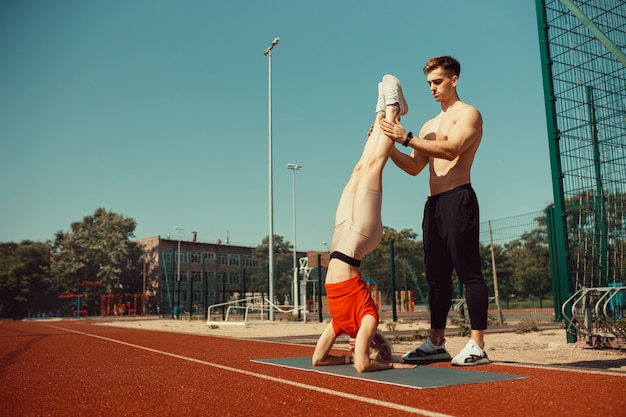 Jonge blonde leert balanceren in een hoofd- en handstand