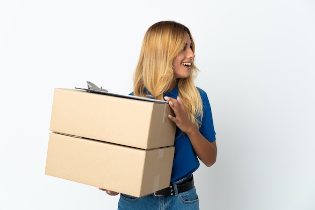 Jonge blonde levering vrouw geïsoleerd lachen in zijpositie