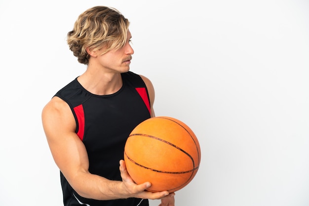 Jonge blonde man geïsoleerd basketbal spelen