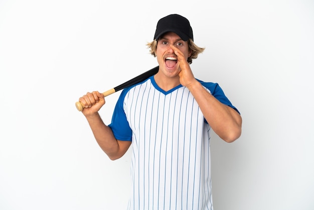 Jonge blonde man honkbal spelen geïsoleerd op een witte muur schreeuwen met wijd open mond