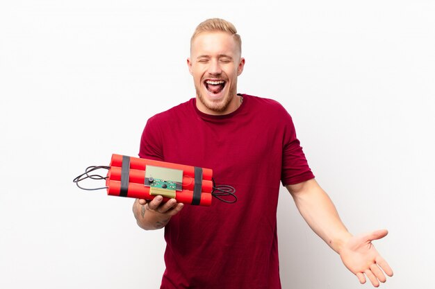 jonge blonde man met een dynamiet pak tong uitsteekt