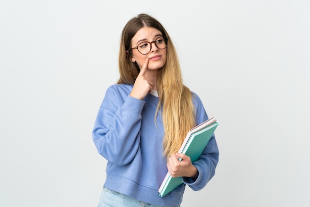 Jonge blonde studentenvrouw die op witte ruimte wordt geïsoleerd die twijfels heeft tijdens het opzoeken