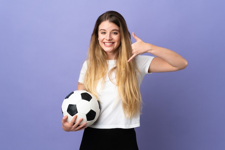 Foto jonge blonde voetbalster vrouw op paars telefoongebaar maken. bel me terug teken