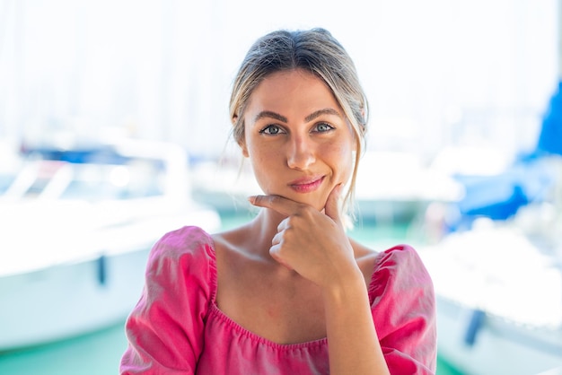 Jonge blonde vrouw buiten aan het nadenken