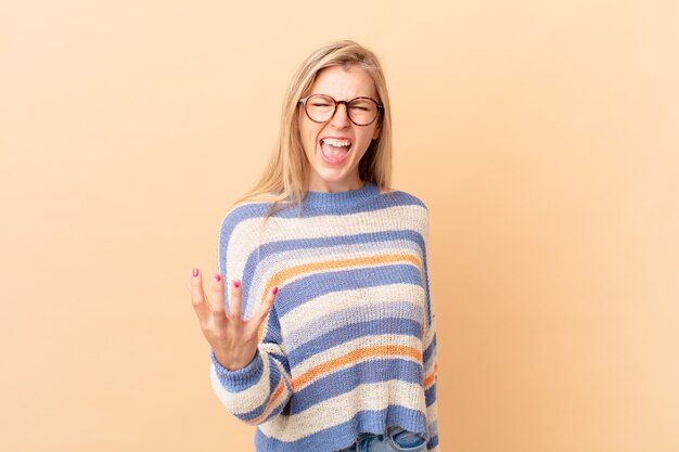 Foto jonge blonde vrouw die boos, geïrriteerd en gefrustreerd kijkt