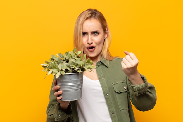 Jonge blonde vrouw die een ongelooflijk succes viert als een winnaar, die opgewonden en blij kijkt en zegt: neem dat!