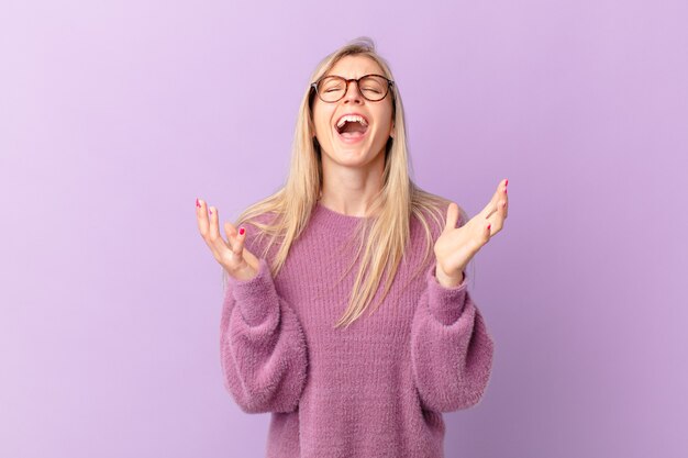 Jonge blonde vrouw die er wanhopig, gefrustreerd en gestrest uitziet