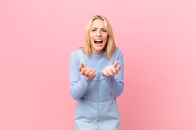 Jonge blonde vrouw die er wanhopig, gefrustreerd en gestrest uitziet