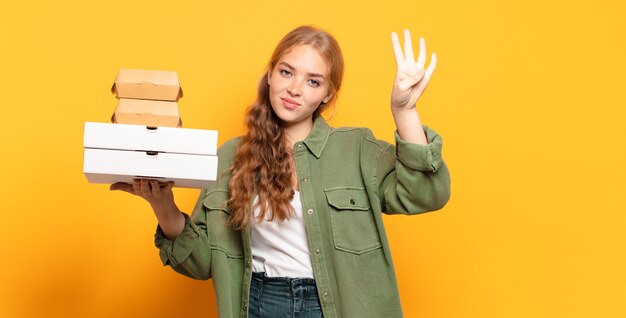 Jonge blonde vrouw die fastfood meeneemt