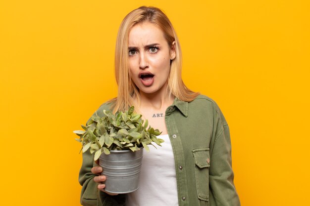 Foto jonge blonde vrouw die geschokt, boos, geïrriteerd of teleurgesteld, met open mond en woedend kijkt