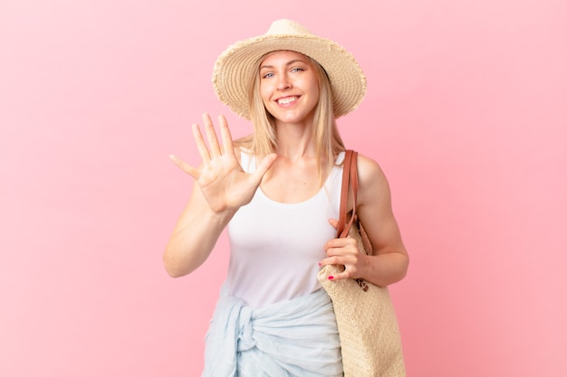 Jonge blonde vrouw die lacht en er vriendelijk uitziet, met nummer vijf