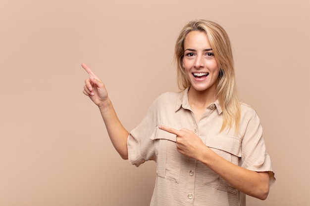 Jonge blonde vrouw die naar de zijkant wijst