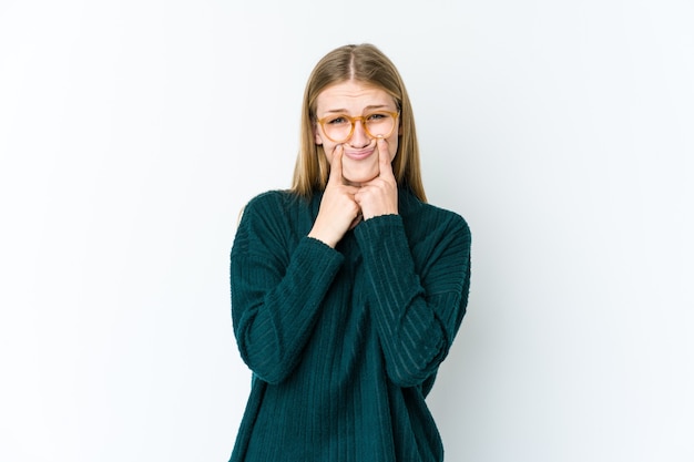 Jonge blonde vrouw die op witte muur wordt geïsoleerd die tussen twee opties twijfelt