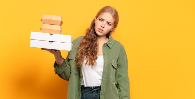 Jonge blonde vrouw die snel voedsel wegneemt