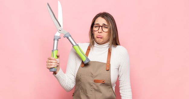 Jonge blonde vrouw die verdrietig en zeurderig is met een ongelukkige blik, huilend met een negatieve en gefrustreerde houding