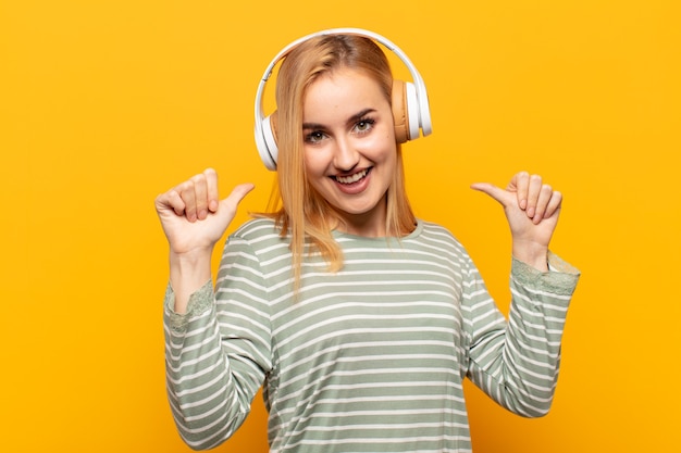 Jonge blonde vrouw die zich trots, arrogant en zelfverzekerd voelt, er tevreden en succesvol uitziet en naar zichzelf wijst