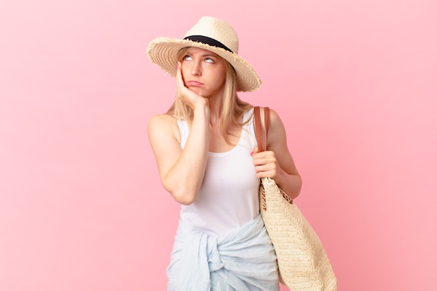 Jonge blonde vrouw die zich verveeld, gefrustreerd en slaperig voelt na een vermoeiende