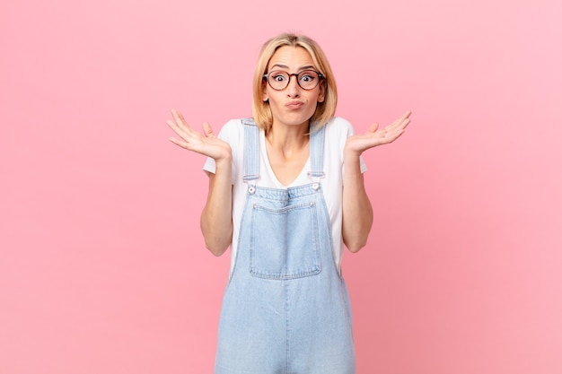 Jonge blonde vrouw die zich verward en verward voelt en twijfelt