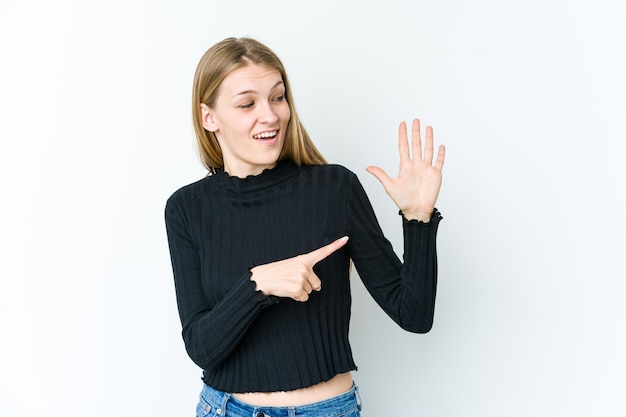 Jonge blonde vrouw geïsoleerd op wit, glimlachend vrolijk tonend nummer vijf met vingers.