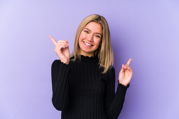 Jonge blonde vrouw geïsoleerd wijzend naar verschillende kopie ruimtes, een van hen kiezen, tonen met vinger