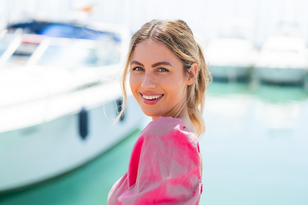 Foto jonge blonde vrouw in de open lucht met gelukkige uitdrukking