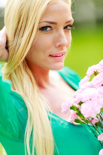 Jonge blonde vrouw met bloemen