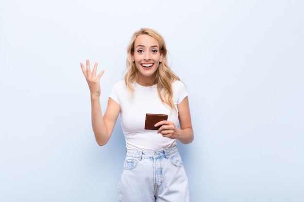 jonge blonde vrouw met een portemonnee gelukkig voelen
